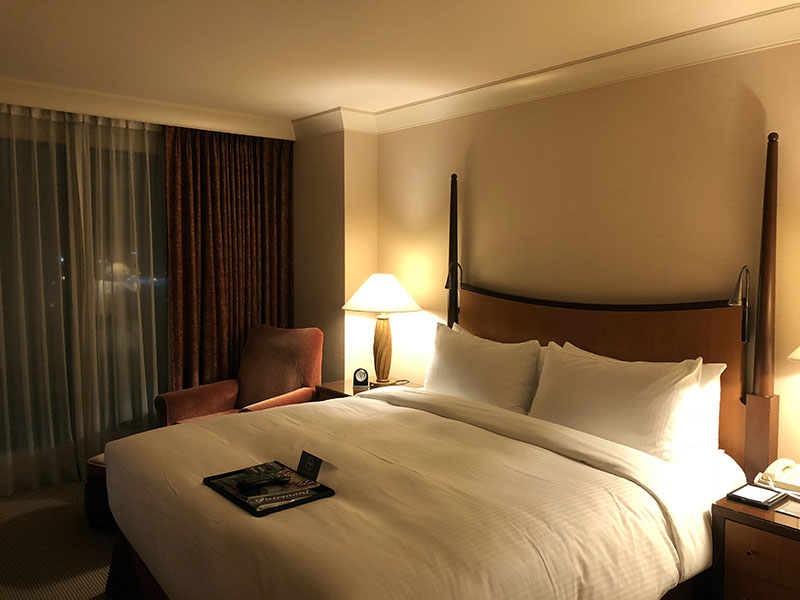 a bed with a lamp and a book on it