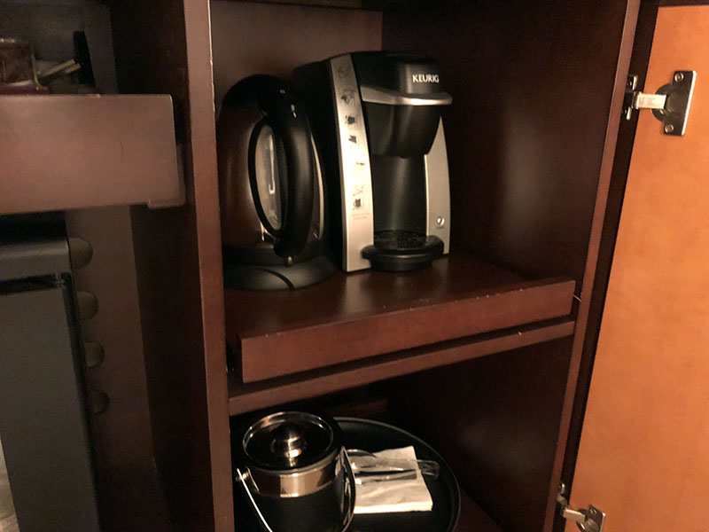 a coffee maker and a pot on a shelf