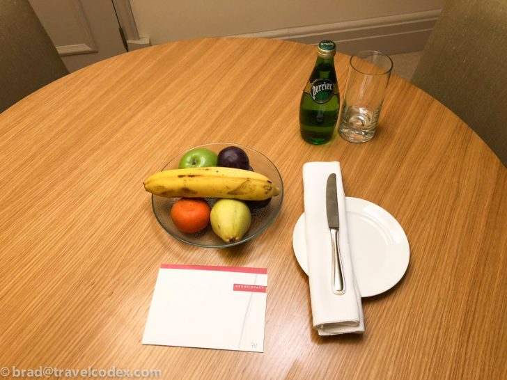 a plate of fruit and a bottle of soda on a table