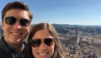 a man and woman taking a selfie with a city in the background