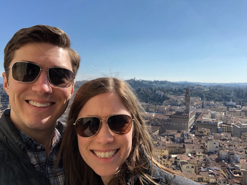 a man and woman taking a selfie with a city in the background