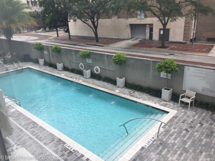 a swimming pool with trees and a building in the background