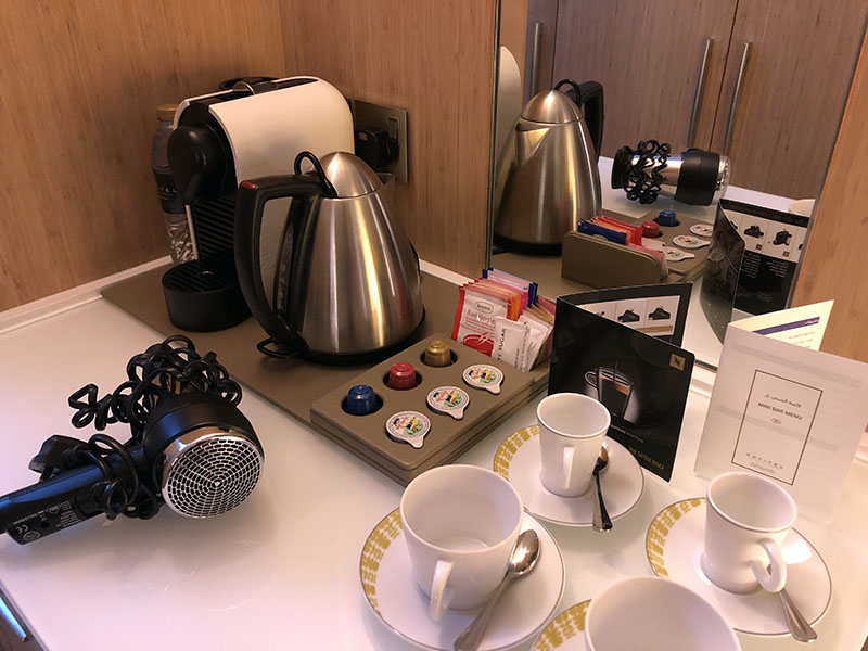 a coffee maker and cups on a table