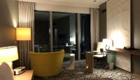 a room with a yellow chair and a table and lamp