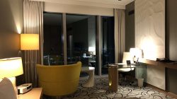 a room with a yellow chair and a table and lamp