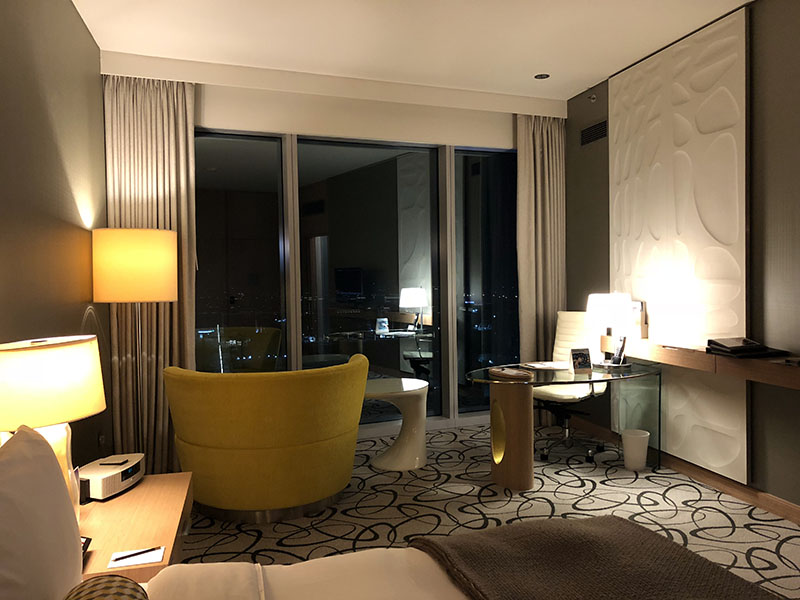 a room with a yellow chair and a table and lamp