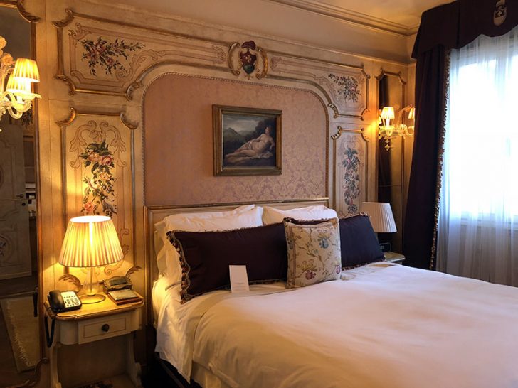 a bed with a lamp and a picture on the wall