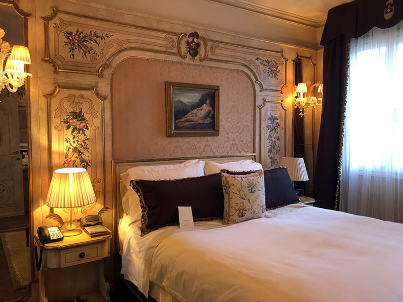 a bed with a lamp and a picture on the wall