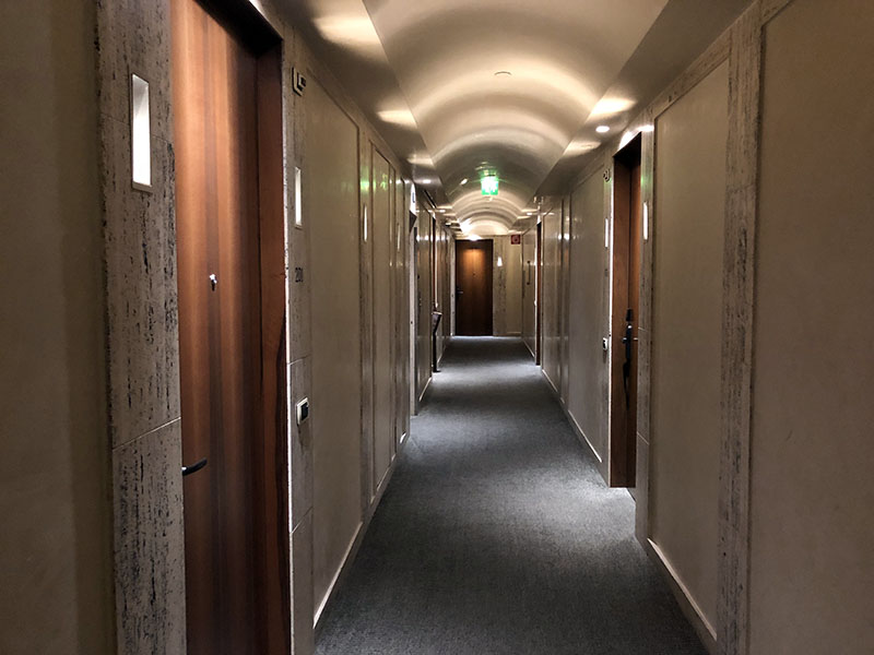 a hallway with doors and a light on the ceiling
