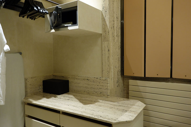 a room with a microwave and a shelf