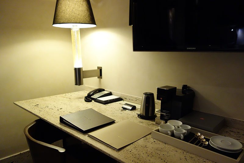 a desk with a lamp and a phone and a notebook
