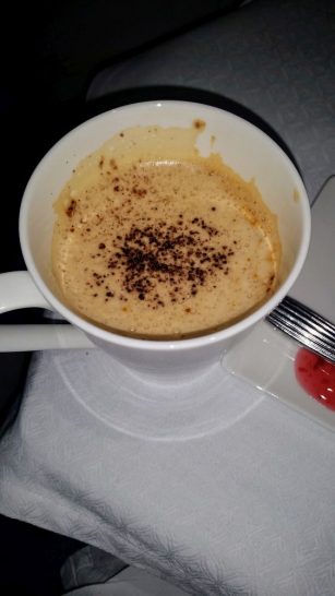 a cup of coffee with a spoon and fork