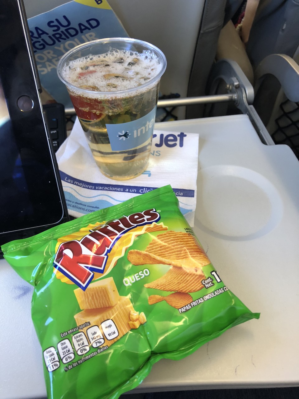 a drink and a bag of chips on a tray