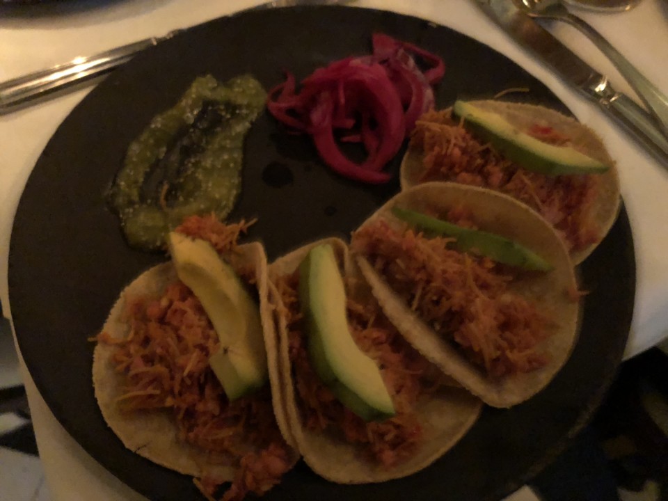 a plate of tacos with vegetables and sauces