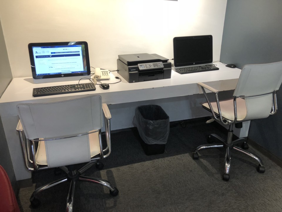 a desk with two laptops and a printer