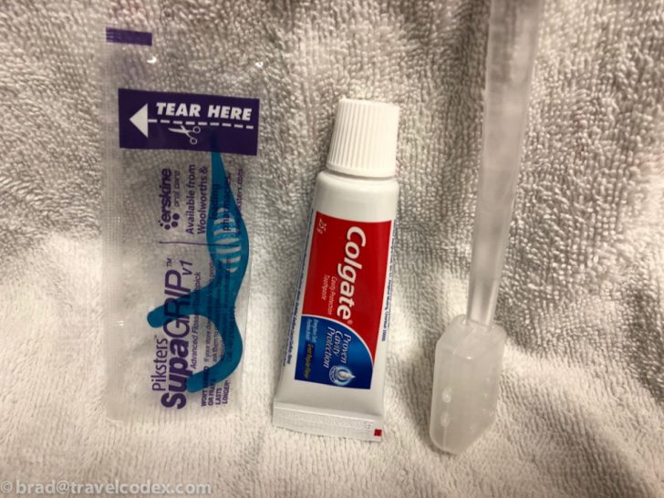 a toothpaste and a toothbrush on a towel