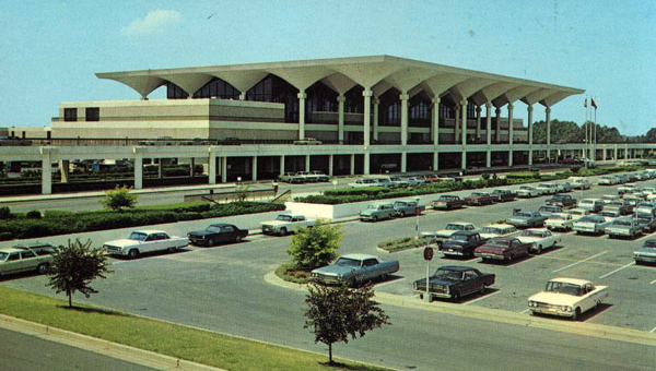 a large building with many cars parked in a parking lot