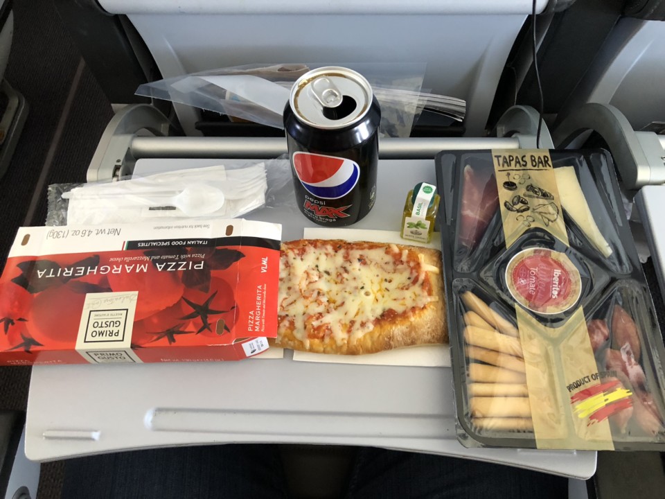food on a tray with a can of soda and a pizza