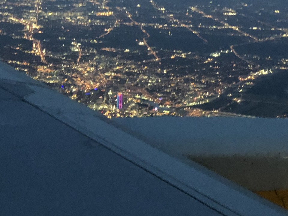 an airplane wing looking out at a city at night