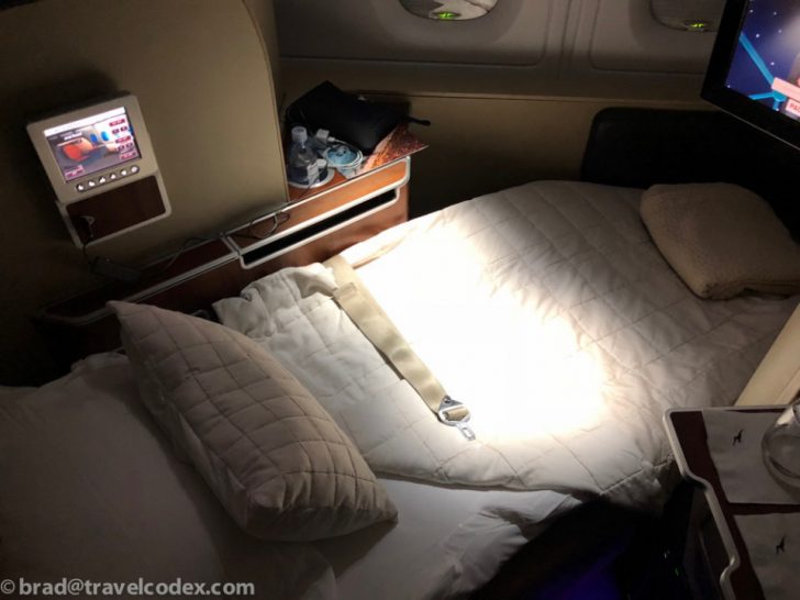 a bed with a seat belt and pillows