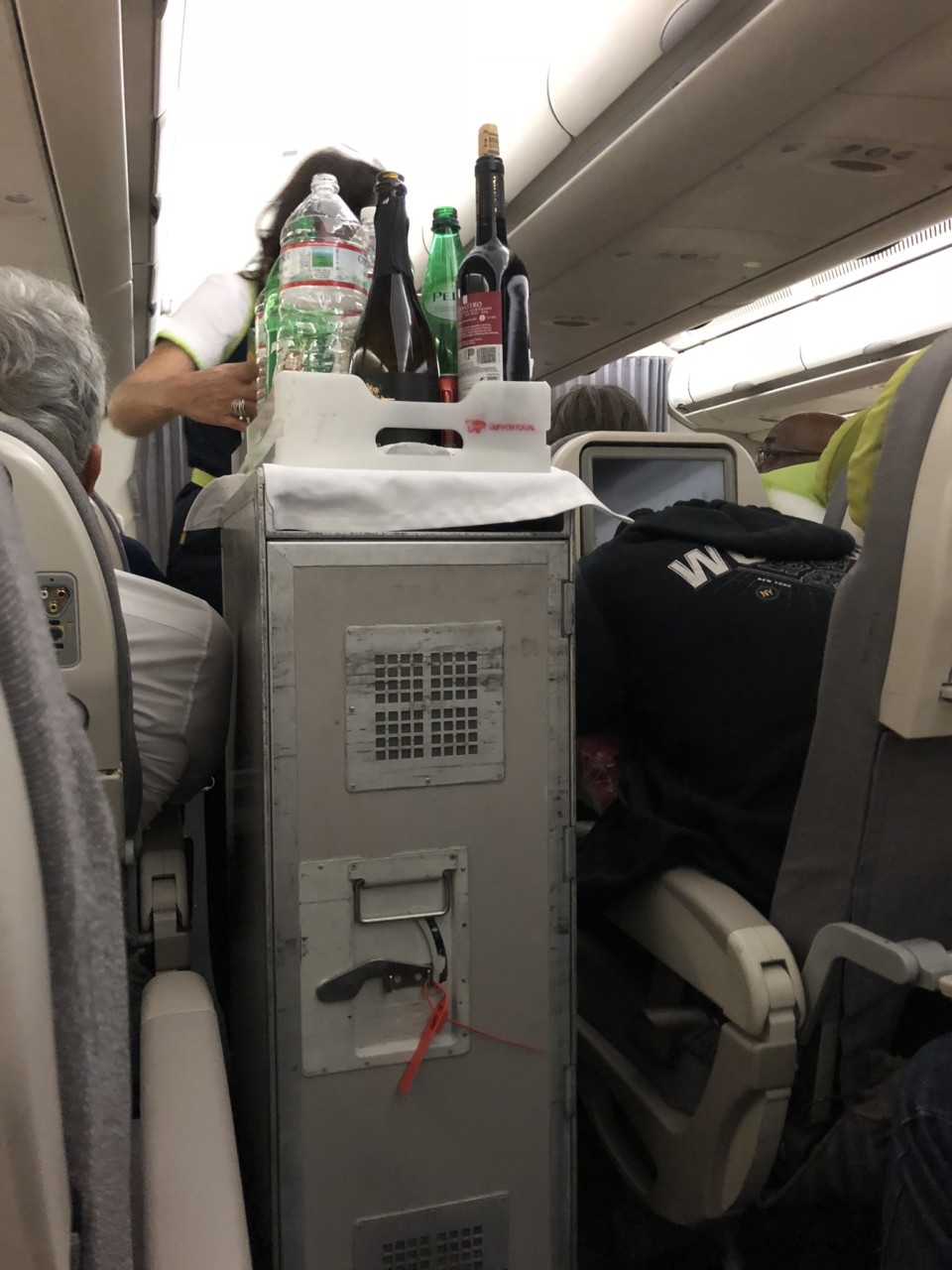 a tray with bottles and bottles on it on an airplane