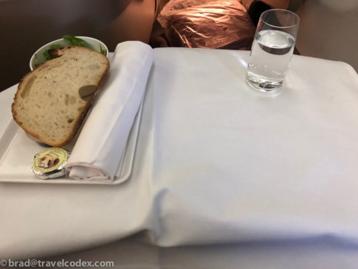 a plate of bread and a glass of water on a table