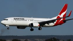 a white and red airplane flying in the sky
