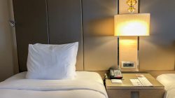 a bed with a lamp and a telephone