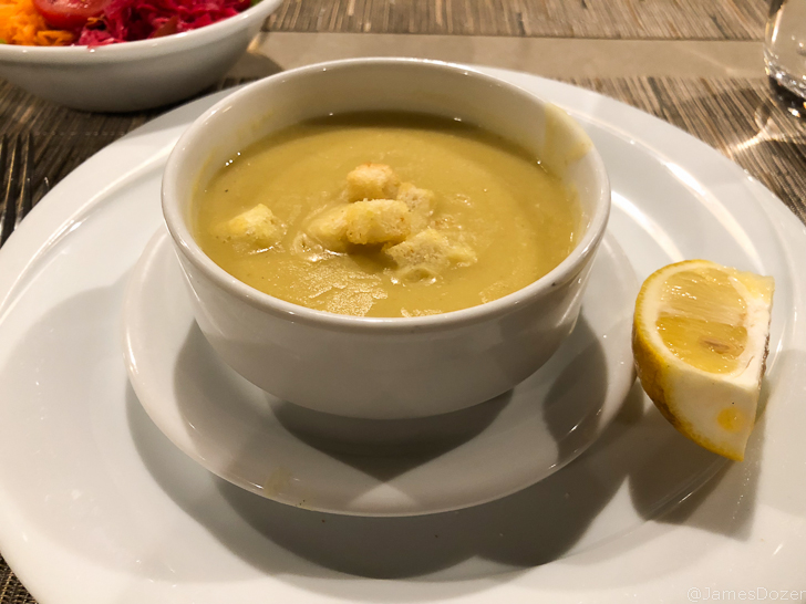 a bowl of soup with a lemon and a bowl of food