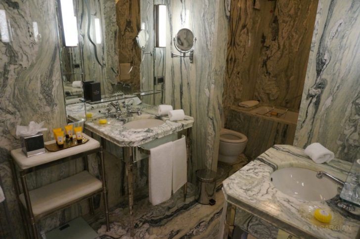 a bathroom with marble walls and sinks