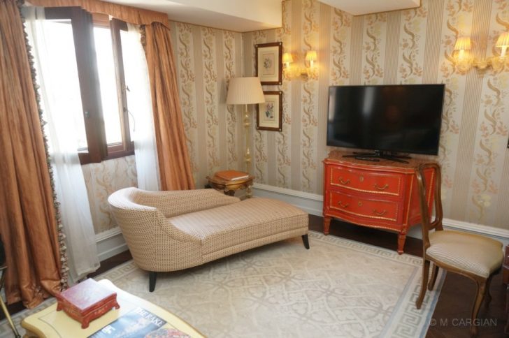 a living room with a chaise lounge and a tv