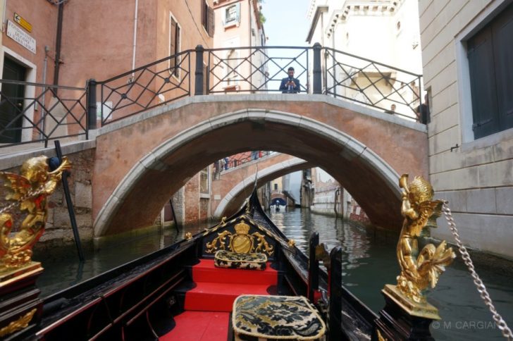 a gondola on a canal under a bridge