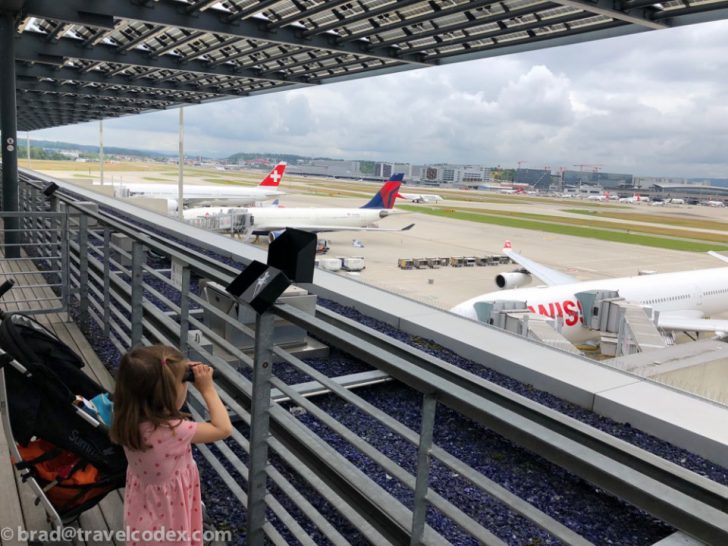 a girl looking at an airplane