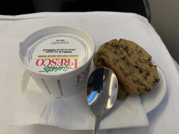 a cookie and a cup of yogurt on a plate
