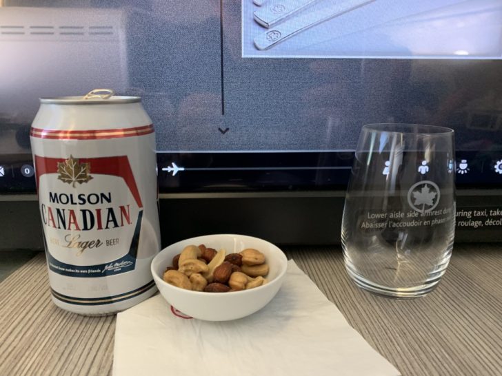 a can of beer and a bowl of nuts