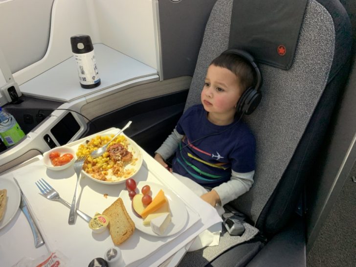 a child sitting in a chair with food on it