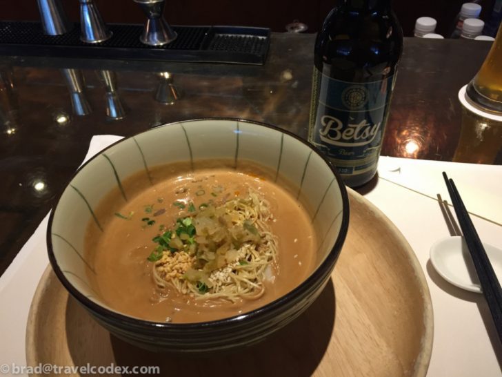 a bowl of soup and a bottle of beer