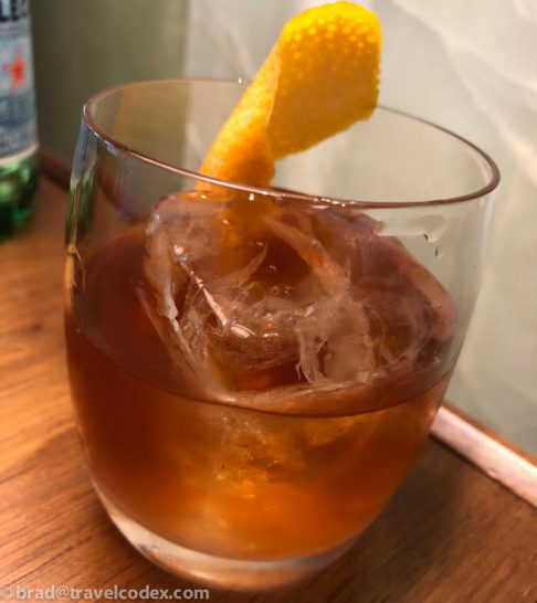 a glass with a drink and a potato chip on it