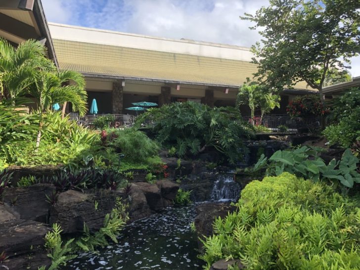 a building with a waterfall and trees