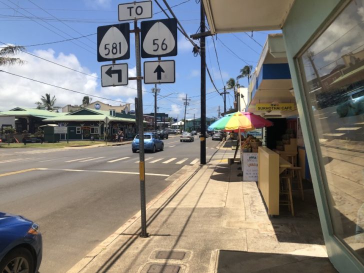 a street with signs and umbrellas on the side