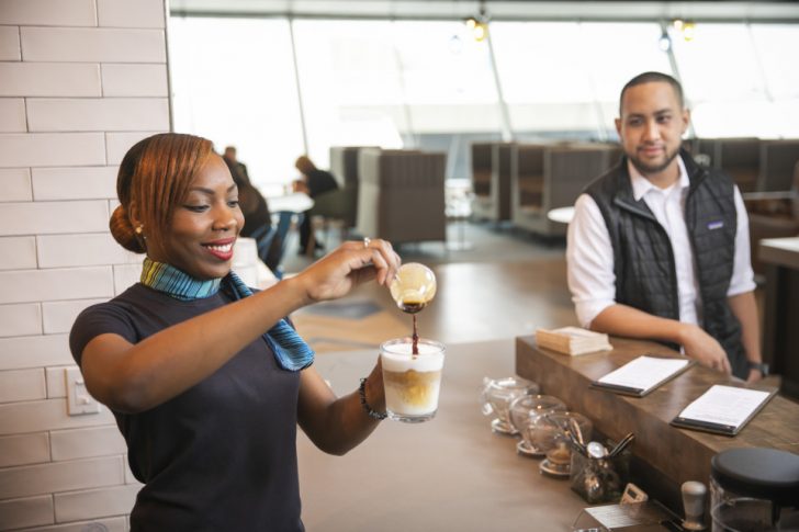 a woman pouring a drink into a glass