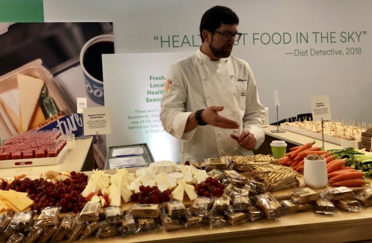 a man standing in front of a table of food