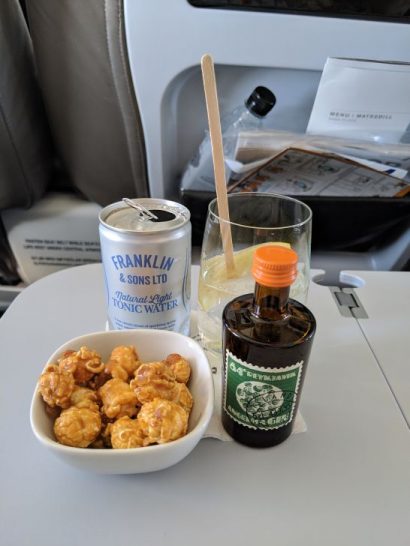 a bowl of popcorn and a drink on a table