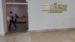 a woman walking in a room with a sign