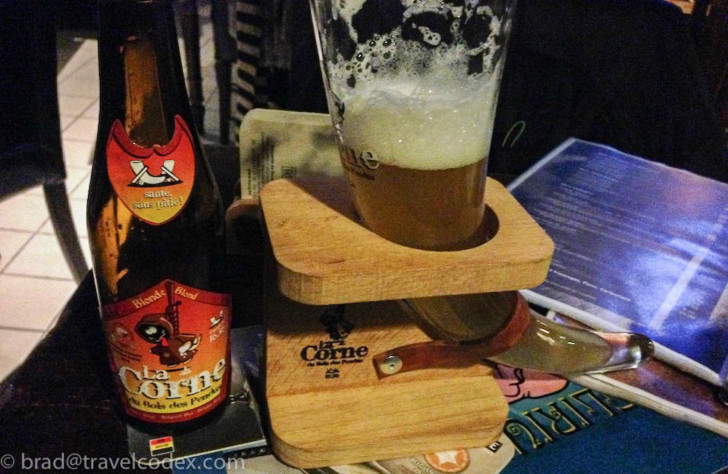 a glass of beer on a wooden stand