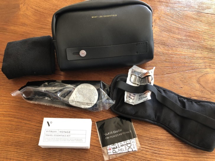 a black bag with a strap and a case on a wooden surface
