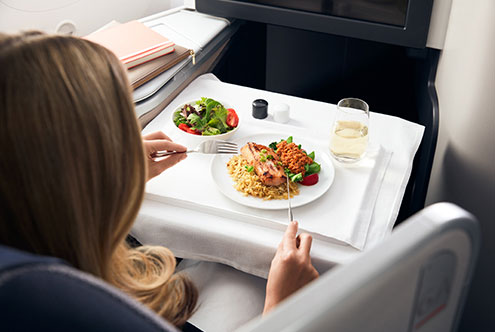 a woman eating food on a plane
