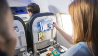a woman pointing at a tablet on a plane