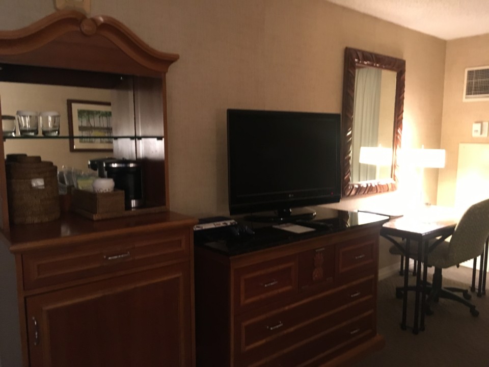 a room with a television and a dresser