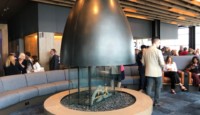 a fireplace in a room with people around it
